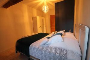 a bedroom with a bed with four pillows on it at Gîte des remparts in Bèze +7 photos