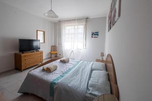 - une chambre avec un lit avec deux animaux rembourrés dans l'établissement Seashore House - Appartamento a 100 mt dal mare, à Villafranca Tirrena