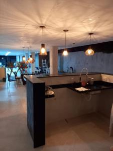 una cucina con lavandino e bancone con luci di Lis zen suite 02 a Porto De Galinhas