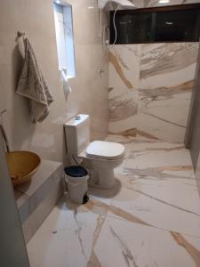bagno bianco con servizi igienici e doccia di Lis zen suite 02 a Porto De Galinhas