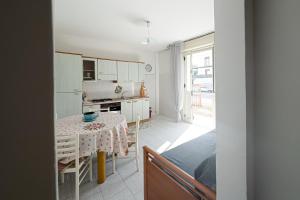 une cuisine et une salle à manger avec une table et une chambre dans l'établissement Seashore House - Appartamento a 100 mt dal mare, à Villafranca Tirrena