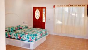 a bedroom with a bed and a red door at Estudio con terraza y vista lago SUEÑOS DE ARENA in Casitas