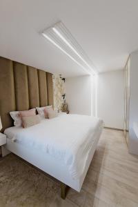 ein Schlafzimmer mit einem großen weißen Bett in einem Zimmer in der Unterkunft Apartman Stari Toranj III in Vukovar