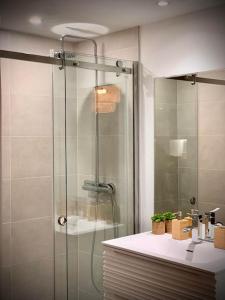 y baño con ducha acristalada y lavamanos. en Loft cosy Menorca 5 étoiles Spa au cœur de Nancy, en Nancy