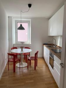 een keuken met een tafel en stoelen en een raam bij Charmante Stadtwohnung im Textilviertel in Augsburg