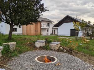 una hoguera en un patio frente a una casa en Klančarjeva domačija - Spacious countryside apartment on an eco farm, 