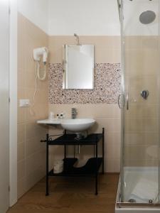 La salle de bains est pourvue d'un lavabo et d'une douche. dans l'établissement Hotel Bella Vita, à Rome