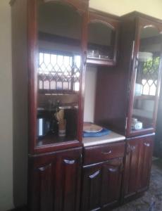 a kitchen with wooden cabinets and a coffee maker at Exclusive Holiday Villa with Pool in Accra in Accra