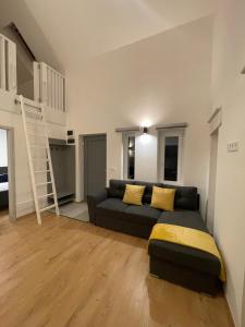 un soggiorno con divano e scala a pioli di Dream Apartman a Levél