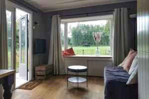 - un salon avec un canapé et une grande fenêtre dans l'établissement Het Zwarte Paard, à Gameren
