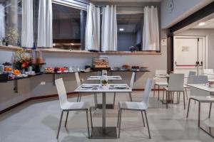 a dining room with white tables and white chairs at Hotel Bella Vita in Rome