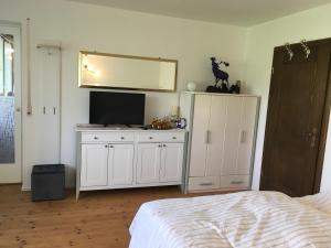 a bedroom with a bed and a tv and a mirror at Ferienwohnung am Moosweg in Siegsdorf