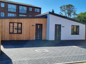 a house with two doors and a building at Pass the Keys 3 Devondale Bungalows Modern bungalow with parking near the beach in Dawlish