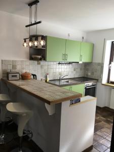 a kitchen with green cabinets and a counter top at Ferienwohnung am Moosweg in Siegsdorf +13 photos
