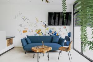 a living room with a blue couch and a table at WellNS Rooms in Novi Sad