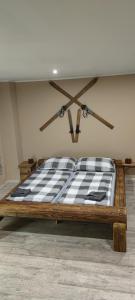 - un lit en bois avec un matelas à damier noir et blanc dans l'établissement Apartmán Houmr, à Jáchymov