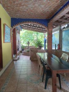 プエルト・エスコンディードにあるMayFlower Hotel & Hostalの木製のテーブルと椅子のあるダイニングルーム