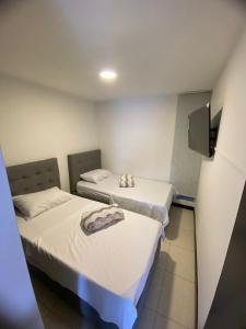2 Betten in einem Krankenhauszimmer mit einem TV in der Unterkunft Guaduales del cafe isabella in Montenegro