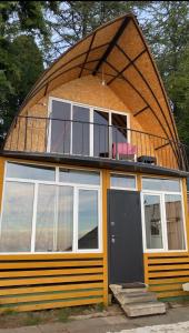 ein rundes Haus mit Balkon darüber in der Unterkunft Дом с видом на море на Белом пляже in Novy Afon