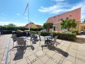 een patio met een tafel en stoelen voor een gebouw bij Toftegården Guesthouse - Rooms in Skagen