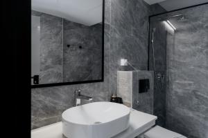 uma casa de banho com um lavatório branco e um chuveiro em WellNS Rooms em Novi Sad
