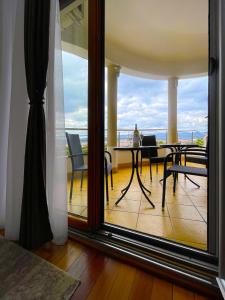 Habitación con balcón con mesa y sillas. en Freya SPA Apartments, en Niš
