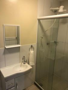 新弗里堡的住宿－Pousada HD，一间带玻璃淋浴和水槽的浴室