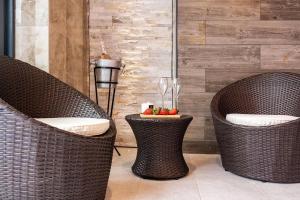 two wicker chairs and a table with wine glasses at Clwyd Gate Manor Pool Sauna HotTub Cave Wales in Ruthin