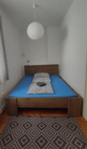 a bed with a blue mattress in a room at Vince apartman in Pécs