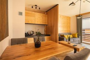 a kitchen and living room with a wooden table and chairs at Maglian Campus in Divčibare