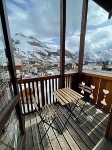 un balcón con banco y montañas cubiertas de nieve en Les deux Alpes : charmant studio, quartier Vénosc en Les Deux Alpes