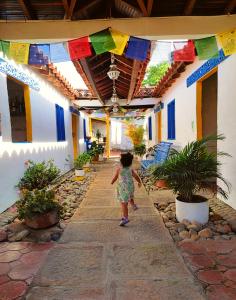 Una bambina che cammina lungo un vialetto in un edificio di Hostel Trip Monkey Barichara a Barichara