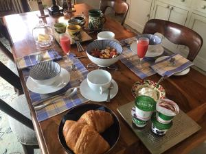 a wooden table with a breakfast of bread and drinks at Brook House in Nunney