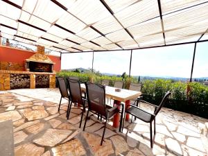 un patio con tavolo, sedie e camino di GKK House private swimming pool luxury house a Skriperón