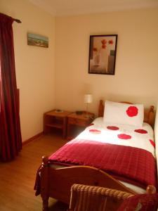 a bedroom with a bed with a red blanket at The Waters Edge in Aughris