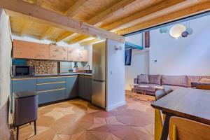 a kitchen and living room with a couch and a table at VEN LUNA, VEN Casa-SPA Astroturismo rural TR-CC-00361 in Casas del Castañar