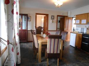 a kitchen with a wooden table and chairs in a kitchen at The Waters Edge in Aughris