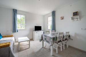 um quarto branco com uma mesa de jantar e cadeiras em Le Balina em Cabriès