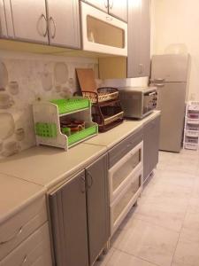a kitchen with white cabinets and green baskets on the counter at Family Hotel "Big House" in Kobuleti