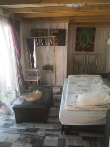 Un dormitorio con una cama y una mesa. en Romantic Woodhouse casita camping, en Aguatona