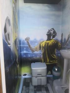 a man in a bathroom with a painting on the wall at Romantic Woodhouse casita camping in Aguatona