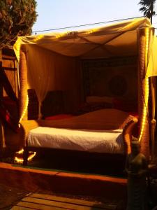 a bedroom with a canopy bed with lights on it at Romantic Woodhouse casita camping in Aguatona