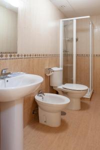 Un baño con lavabo, inodoro y ducha. en Apartamentos Playamarina, en Isla Canela