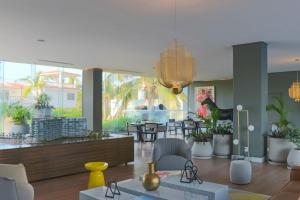 Una sala de estar con sillas y un comedor. en Marítima Playa Beach front Condo with great views, en Nuevo Vallarta 