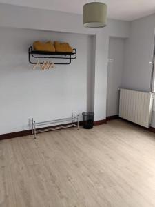 een lege kamer met een witte muur en een houten vloer bij Apartamento Sanfuentes Bat in Sanfuentes