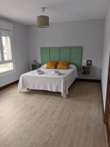 a bedroom with a large bed with a green headboard at Apartamento Sanfuentes Bat in Sanfuentes