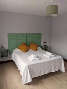 een slaapkamer met een groot bed en 2 handdoeken bij Apartamento Sanfuentes Bat in Sanfuentes