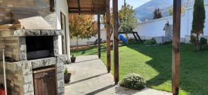 an outdoor patio with a stone fireplace in a yard at Villa Gardenia in Sapareva Banya