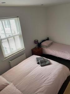 1 dormitorio con 2 camas y ventana en 2 Laurel Court en Ulverston