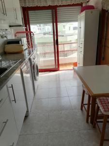 a kitchen with a white refrigerator and a table at Leonel Barcelos in Quarteira +3 photos